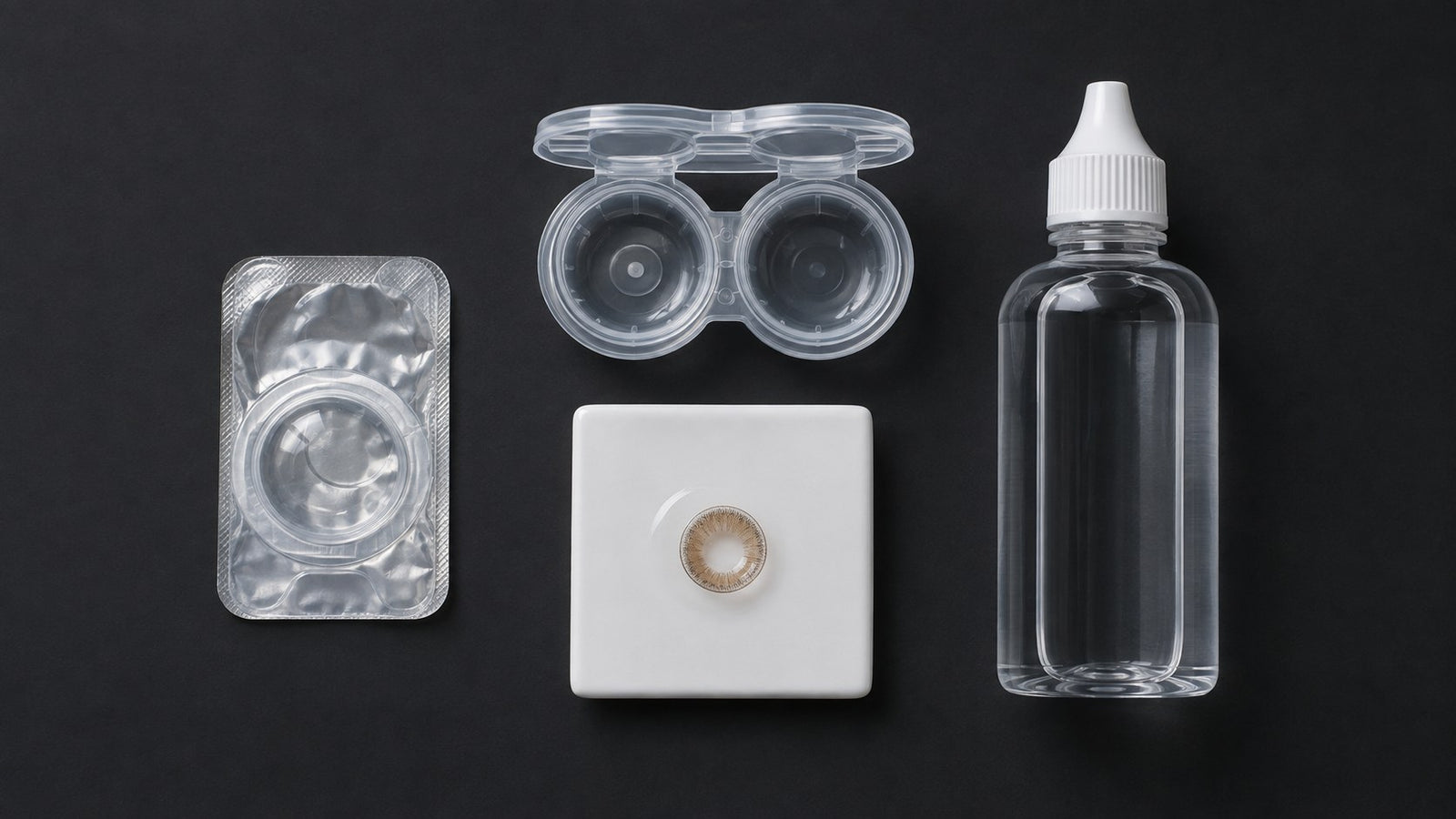 A sealed lens blister, case and solution bottle laid out for inspection