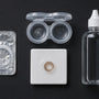 A sealed lens blister, case and solution bottle laid out for inspection