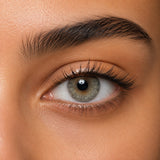Bella Gray Olive coloured contact lens shown on a dark brown eye