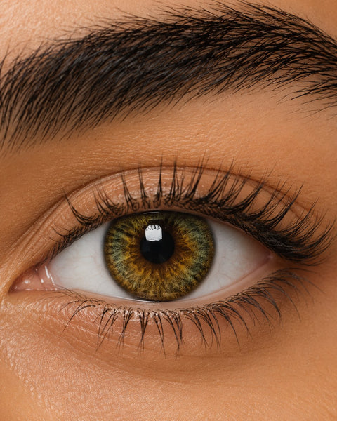 Urban Layer Cleopatra Green coloured contact lens shown on a dark brown eye